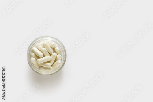 Capsules pills in glass bowl on white background
