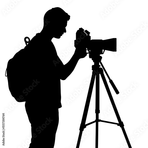 Silhouette of filmmaker adjusting camera on tripod, visual storytelling setup