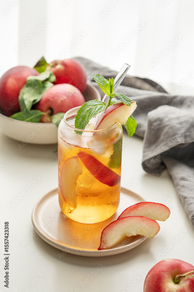 Ice tea with peach, mint in a glass on a white table near window with fresh fruits, napkin and sunlight. Ice tea with peach, mint in a glass on a white table near window with fresh fruits, napkin and sunlight.