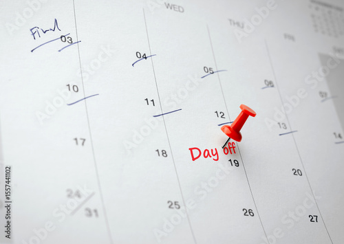 A red pin placed on 19th day of month with written word Day off on white calendar. Concept of Work Life and Balance, a day off from work or vacation to take break from regular work.