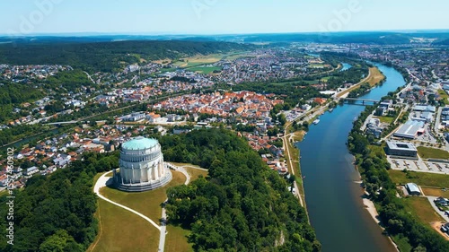 Befreiungshalle in Kelheim, Germany, captured from a drone on a bright summer day. This impressive circular monument stands above the Danube, surrounded by lush green landscape