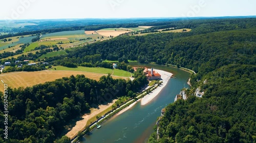 Kloster Weltenburg on the Danube River, Germany, shot from a drone in summer. Historic Benedictine monastery surrounded by forested cliffs and dramatic river curves near Kelheim