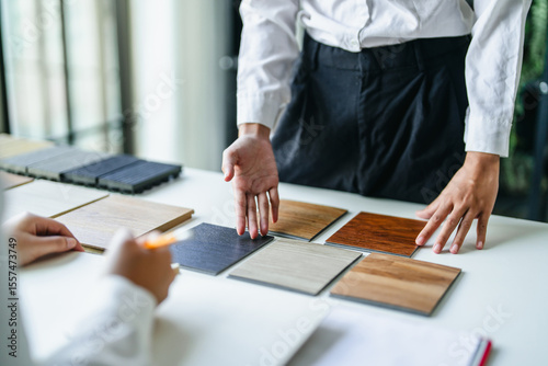 Interior designer discussing wood laminate materials in modern office