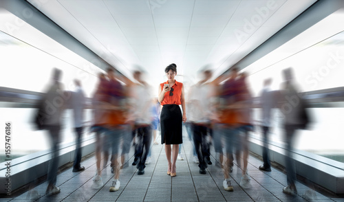 Woman using phone and walking on footbridge