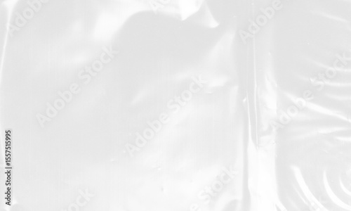 plastic transparent cellophane bag on white background. The texture looks blank and shiny. The plastic surface is wrinkly and tattered making abstract pattern