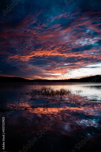Dramatic Sunset Reflected Over Calm Lake Water