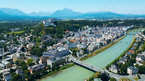 Salzburg, Austria, aerial view of the historic old town with Hohensalzburg Fortress, Salzach River, baroque architecture and surrounding Alps. Captured on a sunny summer day from a drone