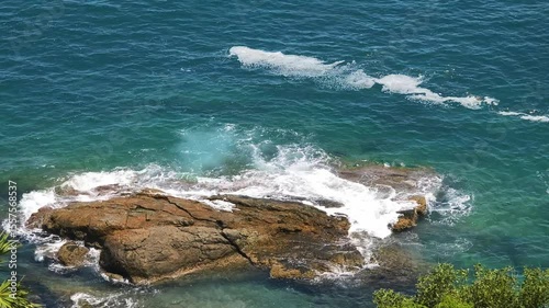 Rocky shoreline where the waves are dramatically crashing against the rocks and stones