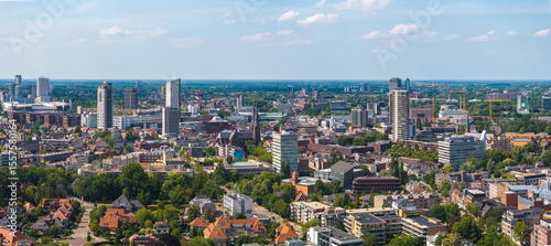 Fotografie Aerial view of Eindhoven, Netherlands, showing Philips Stadium, modern high rises, red roofed houses, lush greenery, and a clear blue sky
