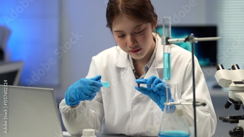 Female scientist in professional lab attire carefully analyzing pharmaceutical samples, conducting meticulous research with precision and focus in modern laboratory environment