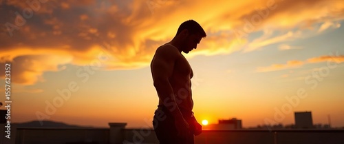 Silhouette of a well-built figure at sunset on a rooftop terrace,  twilight,  building