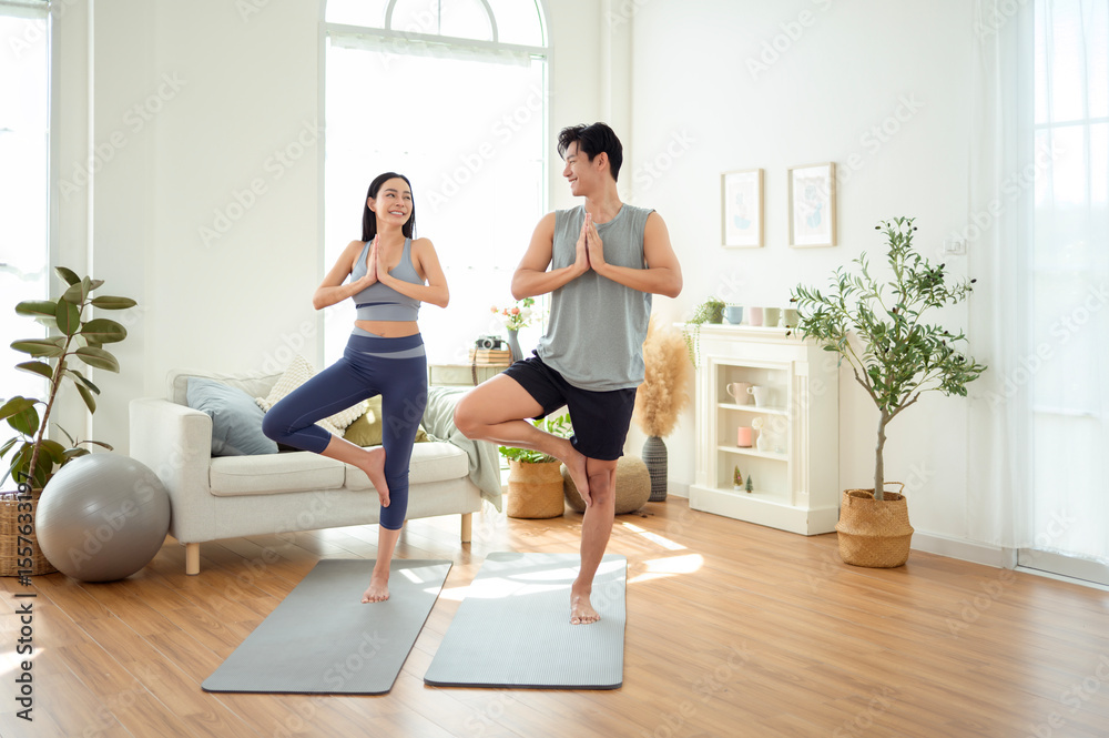 Couple Practicing Yoga in a Bright and Airy Living Room During Early Morning Couple Practicing Yoga in a Bright and Airy Living Room During Early Morning