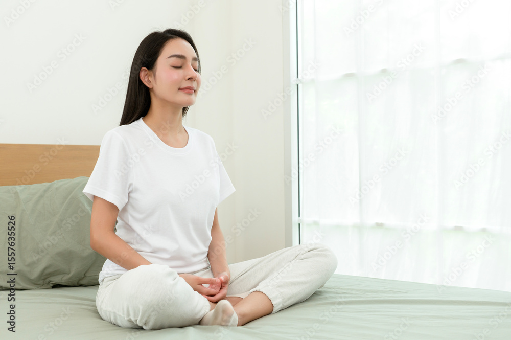 Woman Meditating Quietly on a Bed in a Serene Room During the Early Morning Hours Woman Meditating Quietly on a Bed in a Serene Room During the Early Morning Hours