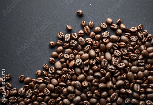 Dark surface strewn with aromatic roasted coffee beans, ready for brewing, brew coffee, grinding