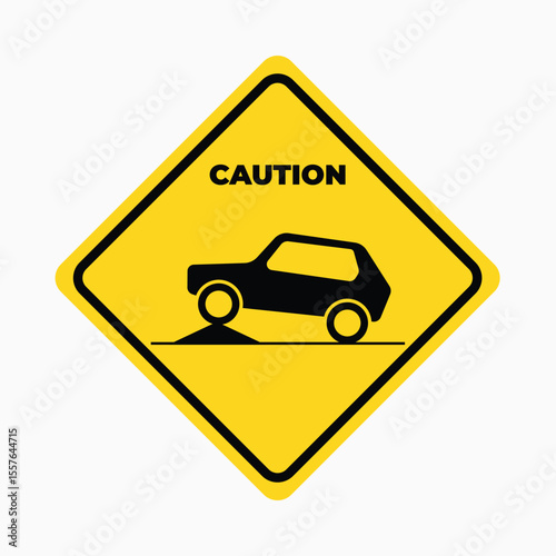 Caution Sign: An eye-catching yellow diamond sign featuring a black car silhouette on uneven ground, communicating a clear message of caution.