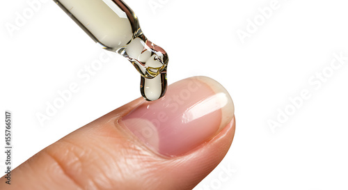 Applying nourishing cuticle oil to a finger with a glass dropper. Macro of a manicure and nail care treatment concept.
