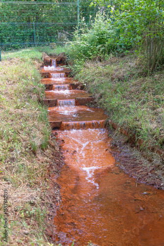 Oxidized iron making spring water rust-coloured in an old mining area.