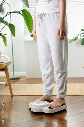 Young woman checking weight at home. Healthy lifestyle concept