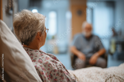 A patient sitting on a hospital bed with a relative nearby.