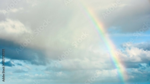 Sky replacement with a part of a colorful rainbow on the right side of clouds.