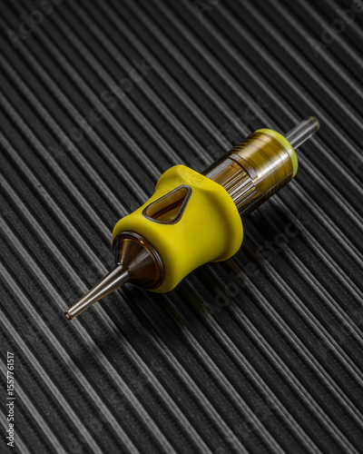 specialized tattoo needle is displayed on a textured surface, highlighting its design and functionality for detailed ink applications in body art.