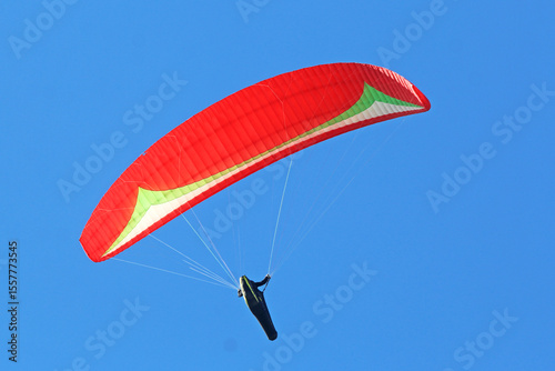 Paraglider flying in a blue sky	