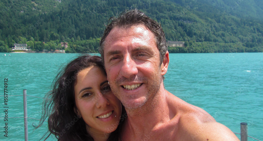 Husband and wife on a pier overlooking Lake Molveno in Trentino, Northern Italy. The man and woman are forty years old and are of Sicilian origin Husband and wife on a pier overlooking Lake Molveno in Trentino, Northern Italy. The man and woman are forty years old and are of Sicilian origin