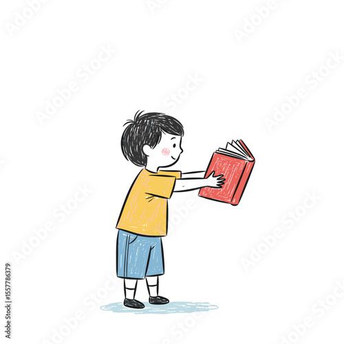 Young boy holding a red book and smiling while standing  