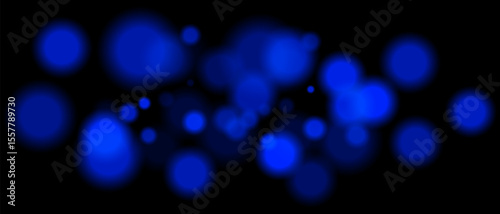 Blue blurred bokeh particles with varying size and opacity on black background. Abstract design element for festive or sci-fi scenes.