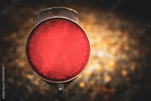 macro close-up of a red reflector, against a blurred background with copy space. 