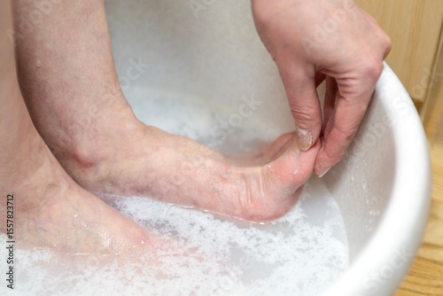 A woman washes and massages her feet.