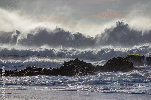 Crashing ocean waves over rocky shore reflect nature’s raw energy and shifting moods