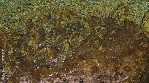 Wallpaper Mural Aerial view of transparent turquoise water over textured rocky seabed. Flight over rippled sea surface Torontodigital.ca