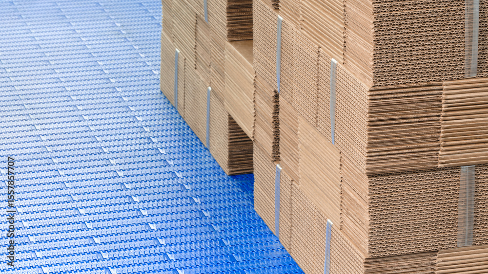 Fototapeta premium Elements of corton boxes are collected in stack. Conveyor line for the production of boxes. Machine cuts cardboard boxes from sheets of cardboard. Enterprise for the production package.