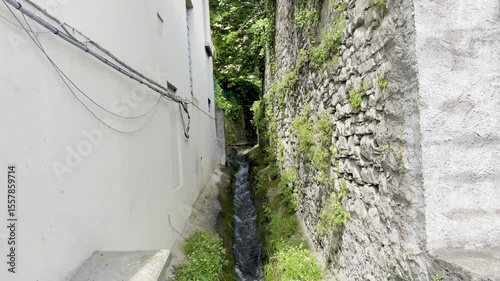 Hidden alleys, ancient cobblestone streets, canal stream, and stone bridges weaving through rustic village corners, with aged walls and local charm