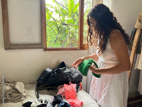 woman dressed in white unpacking her suitcase upon arriving at the lodge