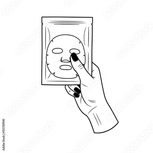 Hand holding a facial mask package, symbolizing skincare and self-care routine