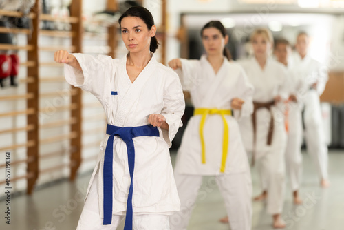 Women in fighting stances at a group karate training. Young Europeans came to the gym for a trial training in martial arts photo