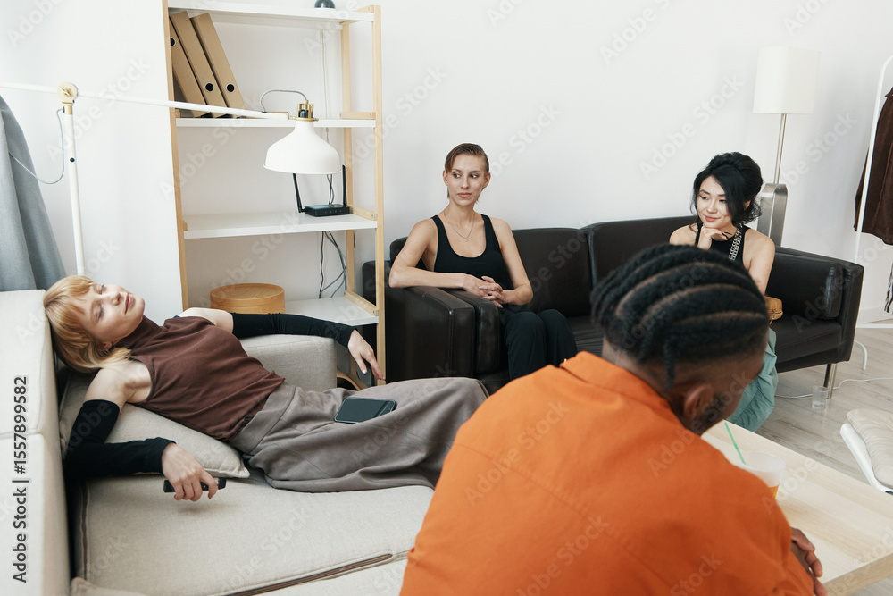 Obraz premium young adult coworkers relaxing and socializing in a modern workplace, Gen Z friends engaging in a casual business meeting, friendly colleagues in work environment