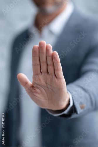 Hand gesture, representing halt. A business man showing stop signal. Prevention, warning, rejection concept. Use for social issues, business ethics.