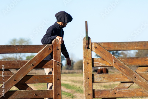 Shot of a Country Man Opening a Wooden Farm Gate in Rural Landscape