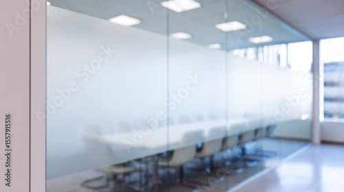 Conference room with frosted glass walls and boardroom chairs around a table. Business, corporate, meeting, office environment