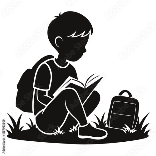 Silhouette of a boy reading a book outdoors with backpack on grass