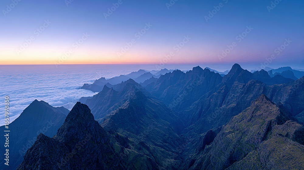 Obraz premium Majestic mountain range above a sea of clouds at dawn.