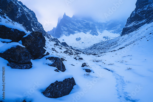 snowy mountain pass in blue hour light, sharp rocky walls and crisp untouched snow, distant trail fading into mist