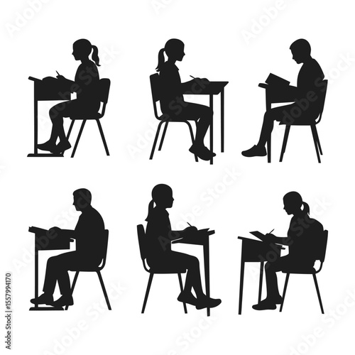 Silhouette of Students Sitting at Desk Reading and Writing in Classroom .

