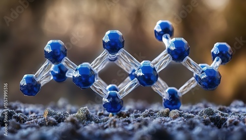 A close-up of an isolated water molecular structure, with clear blue and white hues representing the molecule's glassy surface, set against a blurred background that suggests shallow