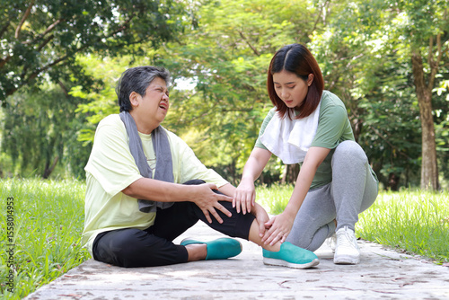 Elderly woman injured ankle from exercise, daughter gives first aid. Proper exercise for the elderly. Reducing the risk of falling in the elderly. Sports concept.