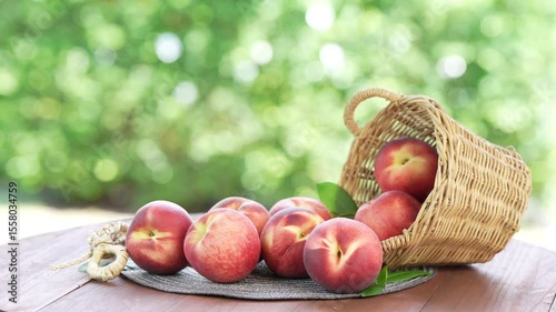 Shine Nectarine in basket on wooden table in garden, Shine Nectarine with leaves on blur background.