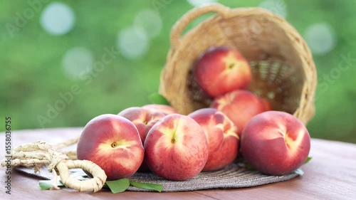 Shine Nectarine in basket on wooden table in garden, Shine Nectarine with leaves on blur background.